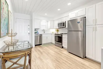 a kitchen with white cabinets and a stainless steel refrigerator at Gulf Front, Seagrove Beach, Sleeps 6, 1st floor, private beach access!! in Seagrove Beach
