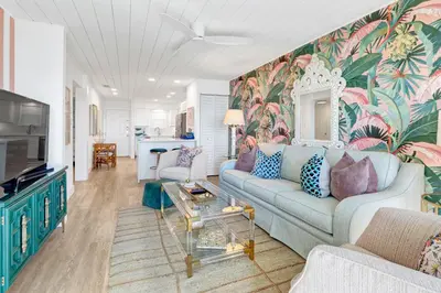 a living room with a blue couch and a colorful wall at Gulf Front, Seagrove Beach, Sleeps 6, 1st floor, private beach access!! in Seagrove Beach