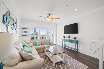 a living room with a couch and a tv at Beach House - Riviera Retreat by Panhandle Getaways in Panama City Beach