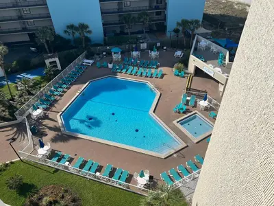 an overhead view of a large swimming pool with lounge chairs and sidx sidx at Seaview Studio at Top of the Gulf #823 by Nautical Properties in Panama City Beach