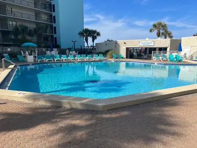 a large swimming pool with blue chairs in a building at Seaview Studio at Top of the Gulf #823 by Nautical Properties in Panama City Beach