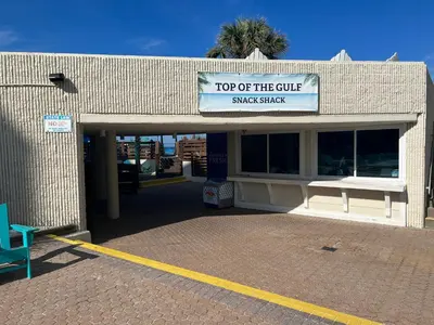 a building with a sign that reads top of the cure snack shack at Seaview Studio at Top of the Gulf #823 by Nautical Properties in Panama City Beach