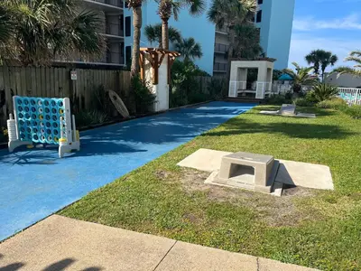 a sandbox in the grass next to a building at Seaview Studio at Top of the Gulf #823 by Nautical Properties in Panama City Beach