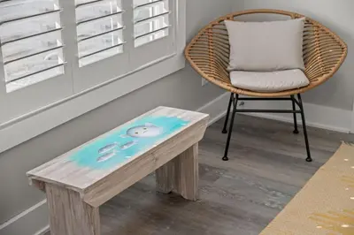 a wicker chair and a table with a pillow at Blue Tide Hideaway - Golf Cart, Sznl Hot Tub, Pets OK, FREE Daily Activities, & More! in Panama City