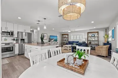 a kitchen and living room with a table and chairs at Blue Tide Hideaway - Golf Cart, Sznl Hot Tub, Pets OK, FREE Daily Activities, & More! in Panama City