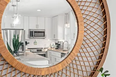 a kitchen with white cabinets and a mirror at Blue Tide Hideaway - Golf Cart, Sznl Hot Tub, Pets OK, FREE Daily Activities, & More! in Panama City