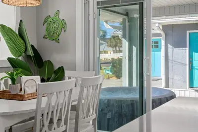 a dining room with a table and chairs and a tub at Blue Tide Hideaway - Golf Cart, Sznl Hot Tub, Pets OK, FREE Daily Activities, & More! in Panama City