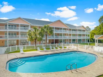a pool in front of a large apartment building at Peachtree Place Ii C202 in Panama City Beach