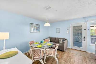 a living room with a table and a couch at Peachtree Place Ii C202 in Panama City Beach