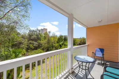 a screened porch with a table and chairs on it at Peachtree Place Ii C202 in Panama City Beach