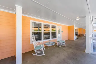 a room with two chairs and a table and windows at Peachtree Place Ii C202 in Panama City Beach