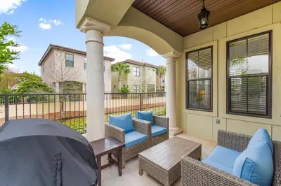 a patio with wicker chairs and a wooden table at Peachtree Place Ii C202 in Panama City Beach