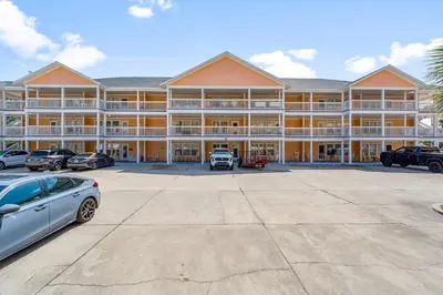 a large building with cars parked in a parking lot at Peachtree Place Ii C202 in Panama City Beach