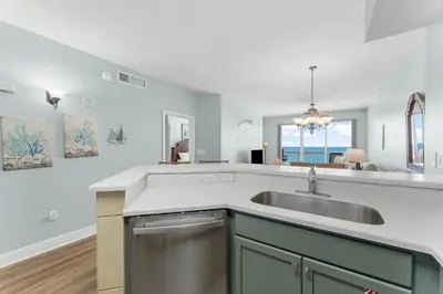 a kitchen with a sink and a living room at Celadon #0808 in Panama City Beach
