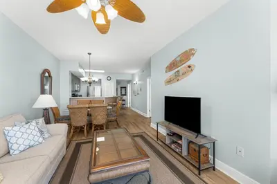 a living room with a couch and a flat screen tv at Celadon #0808 in Panama City Beach