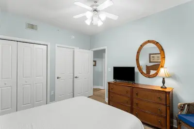 a bedroom with a bed and a mirror and a dresser at Celadon #0808 in Panama City Beach