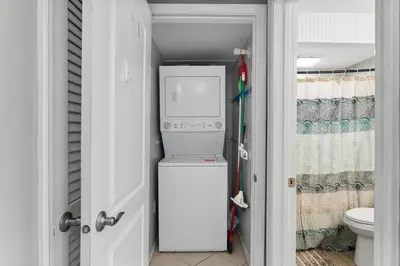 a small refrigerator in a bathroom with a toilet at Regency Towers #0307 in Panama City Beach