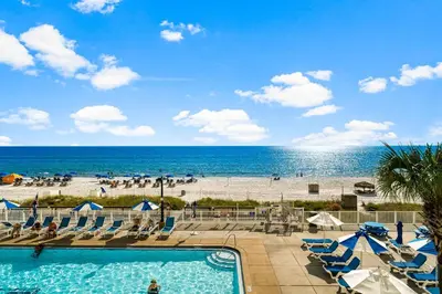 a swimming pool with a beach in the background at Regency Towers #0307 in Panama City Beach
