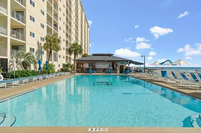 a large swimming pool with chairs and a building at Regency Towers #0307 in Panama City Beach
