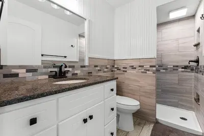 a bathroom with a sink and a toilet and a mirror at Regency Towers #0307 in Panama City Beach
