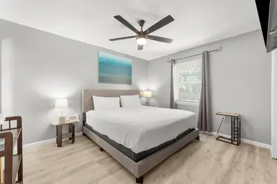 a bedroom with a bed and a ceiling fan at Sunset Haus in Panama City Beach