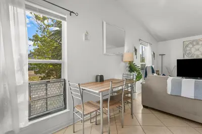 a dining room with a table and chairs next to a window at Sunset Haus in Panama City Beach