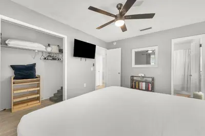 a bedroom with a white bed and a ceiling fan at Sunset Haus in Panama City Beach