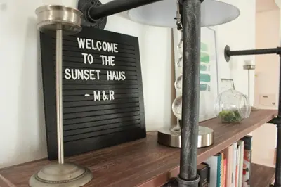 a welcome to the sunset has me sign on a book shelf at Sunset Haus in Panama City Beach