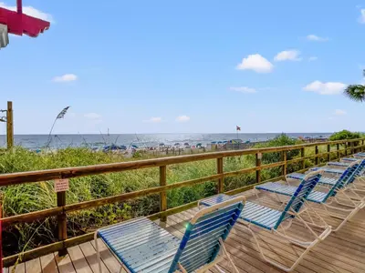 a row of chairs sitting on a deck near the beach at Majestic Beach Towers #2-1203 in Panama City Beach