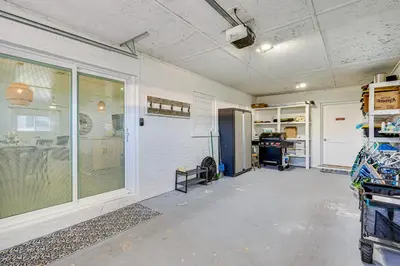 an empty room with a kitchen with a refrigerator at Walk to Beach Chic PCB Getaway with Yard in Panama City Beach