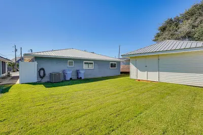 a yard next to a house with a garage at Walk to Beach Chic PCB Getaway with Yard in Panama City Beach