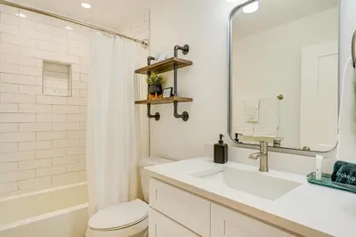 a bathroom with a sink and a toilet and a mirror at Walk to Beach Chic PCB Getaway with Yard in Panama City Beach