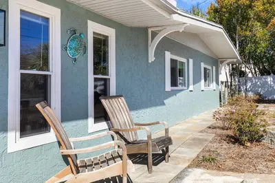 two chairs sitting on the porch of a house at Shells Family Beach House Coastal Retreat with Private Pool Golf Cart & Steps to the Beach in Panama City Beach