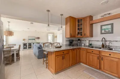 a kitchen with wooden cabinets and a counter top at Shells Family Beach House Coastal Retreat with Private Pool Golf Cart & Steps to the Beach in Panama City Beach