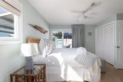 a white bedroom with a bed and a window at Shells Family Beach House Coastal Retreat with Private Pool Golf Cart & Steps to the Beach in Panama City Beach