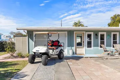 a golf cart parked in front of a house at Shells Family Beach House Coastal Retreat with Private Pool Golf Cart & Steps to the Beach in Panama City Beach