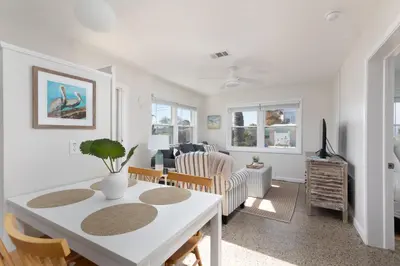 a living room with a white table and chairs at Shells Family Beach House Coastal Retreat with Private Pool Golf Cart & Steps to the Beach in Panama City Beach