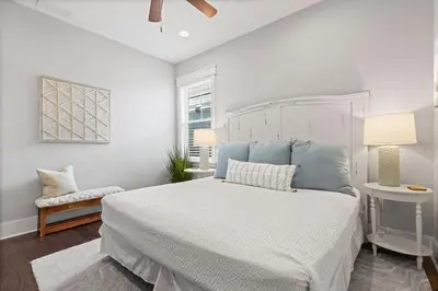 a white bedroom with a white bed and a window at Seagrove Sunshine in Seagrove Beach
