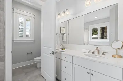 a white bathroom with a sink and a toilet at Seagrove Sunshine in Seagrove Beach