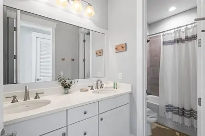 a white bathroom with two sinks and a toilet at Seagrove Sunshine in Seagrove Beach