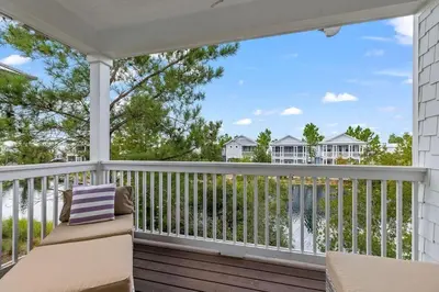 a porch with a bench and a view of condos at Seagrove Sunshine in Seagrove Beach