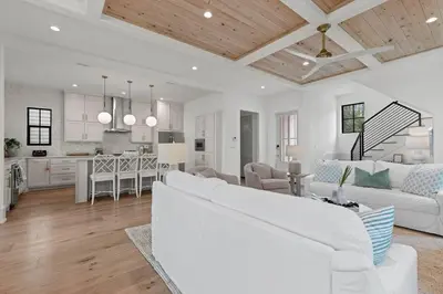 a living room with a white couch and a kitchen at Coastal Charm in Inlet Beach