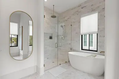 a white bathroom with a tub and a mirror at Coastal Charm in Inlet Beach