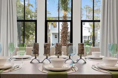 a table with glasses and plates on it with windows at Coastal Charm in Inlet Beach