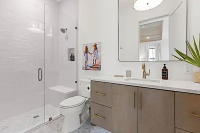 a white bathroom with a toilet and a shower at Coastal Charm in Inlet Beach