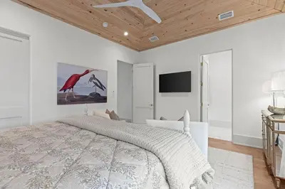 a bedroom with a bed and a flat screen tv at Coastal Charm in Inlet Beach