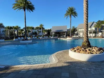 a large swimming pool with palm trees in a resort at BIG EASY on 30A in Watersound Beach