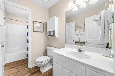 a white bathroom with a toilet and a sink at Balconies with a View at Horizon South 54-302 in Panama City Beach