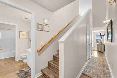 a staircase in a home with white walls and wood floors at Balconies with a View at Horizon South 54-302 in Panama City Beach