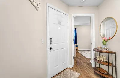 a hallway with a white door and a mirror at Balconies with a View at Horizon South 54-302 in Panama City Beach